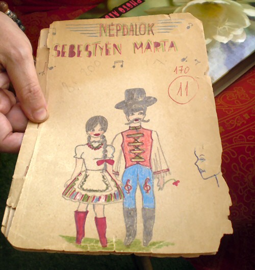 Το παλιό σημειωματάριο της Marta με 170 παραδοσιακά τραγούδια. Η προσήλωσή της στη μουσική είναι φανερή στο σκίτσο της, όπου στα πόδια του χορευτή υπάρχουν μουσικά «κλειδιά»